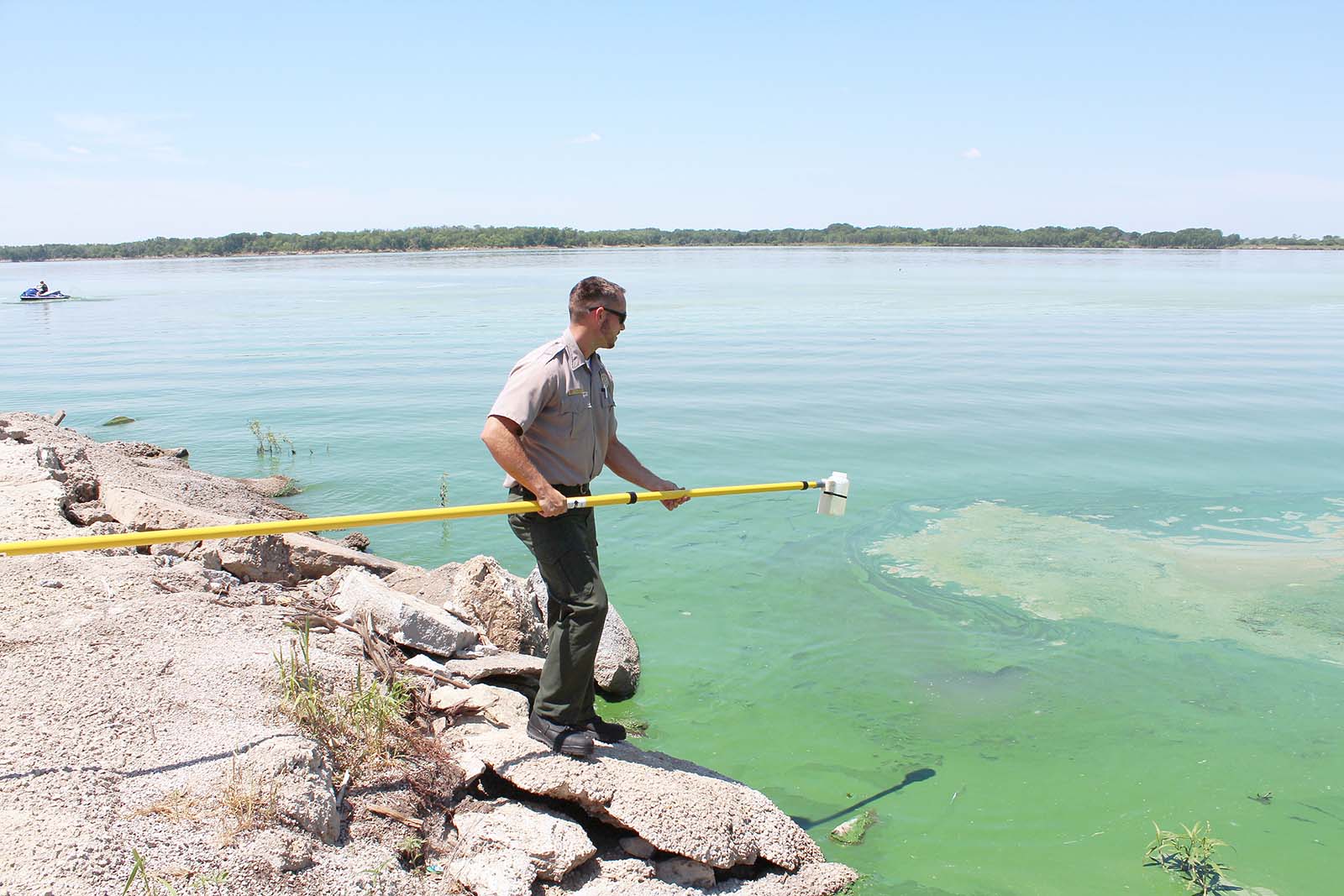 A U.S. Army Corps of Engineers ranger samples at Milford Lake, Kansas, during a harmful algal bloom event in the summer of 2021. (USACE photo by Kansas City District)